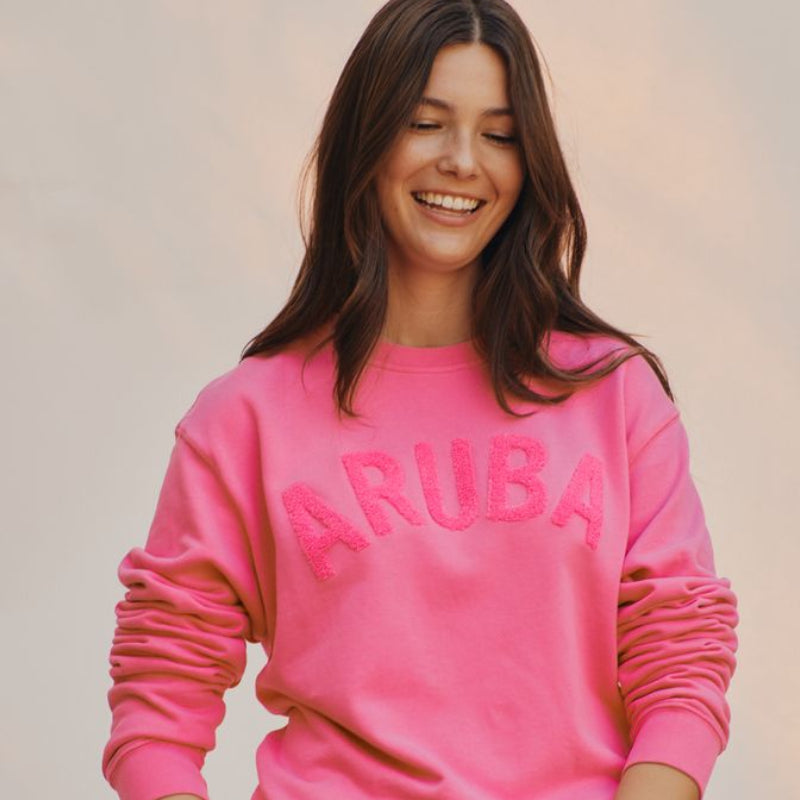 Woman wearing a pink sweatshirt with 'RUB' text on a plain background