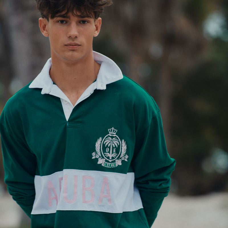 Person wearing a green and white sports jersey with 'AUBA' branding outdoors.