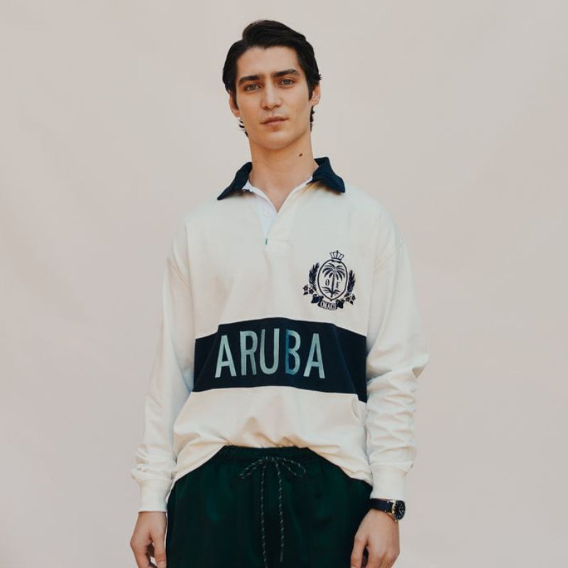 Man wearing a white rugby shirt with 'ARUBA' on a plain background